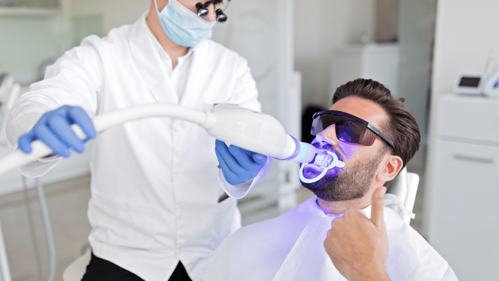 dentist having a teeth whitening procedure with a man